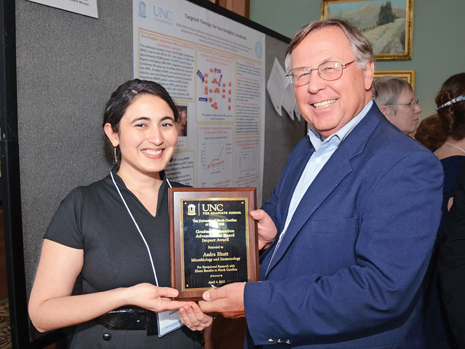 Harold Glass presents 2012 Impact Award recipient Aadra Bhatt with a plaque to honor her research.