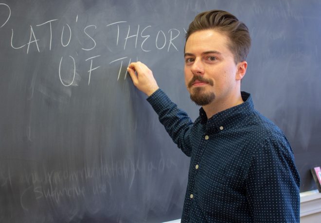 Phil Bold stands at a classroom chalkboard.
