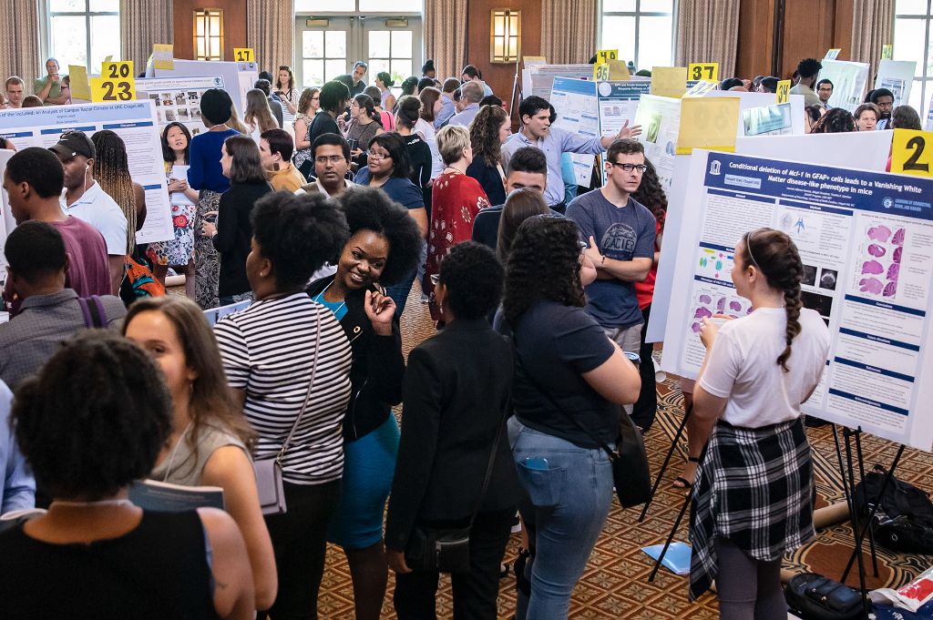 A crowd of researchers, posters and attendees at the Summer Undergraduate Pipeline Research Symposium