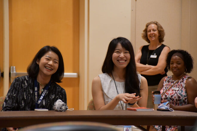 Several people smile during an orientation session