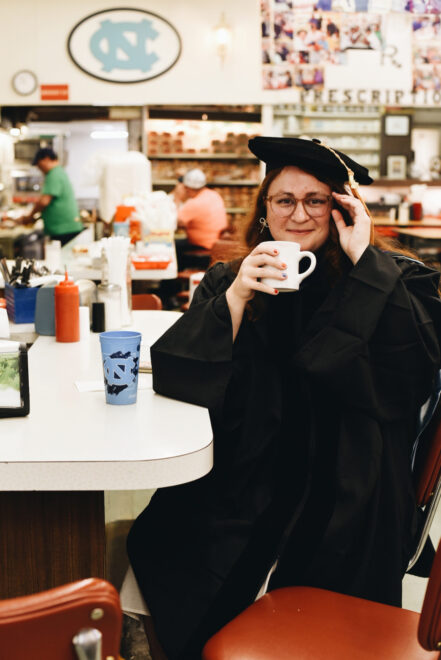 A woman in a drug store with a cup of coffee