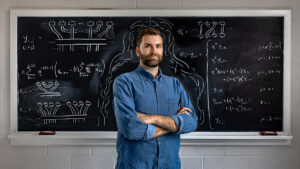 Andrew Adair stands in front of chalkboard